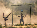 Kids playing football on a flooded ground